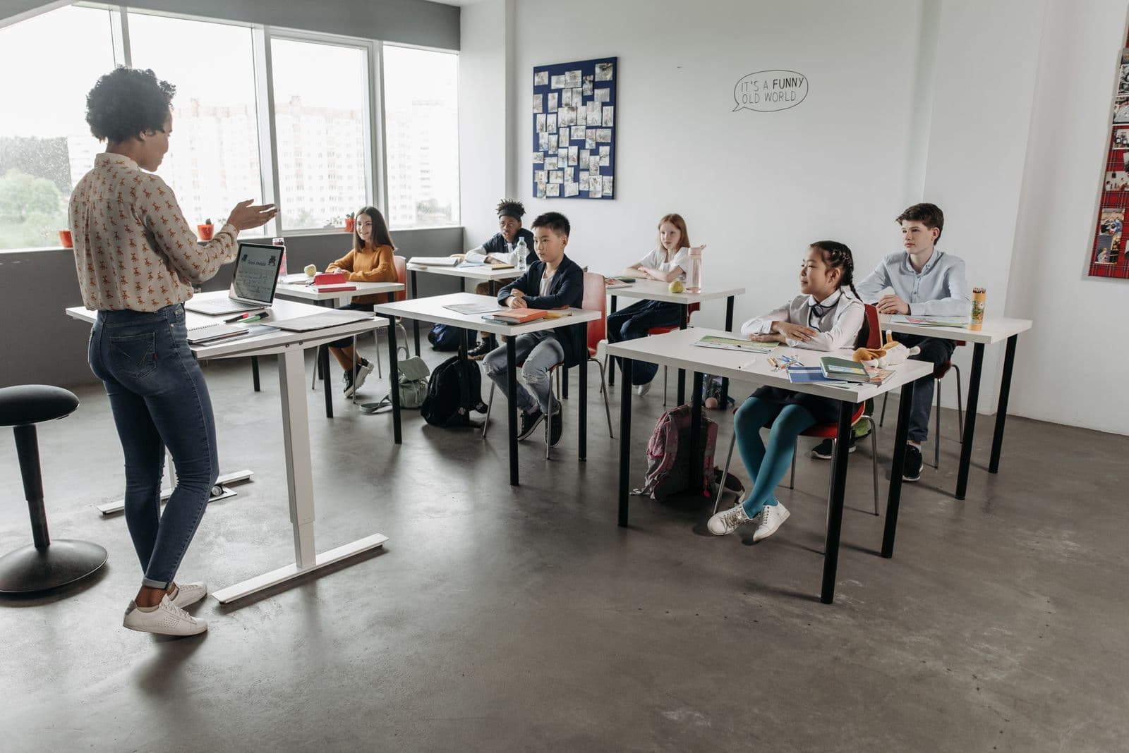Profesora explicando una lección a un grupo de alumnos en un aula moderna.